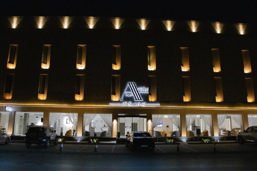 a large building with cars parked in front of it at Triple A Hotel in Riyadh