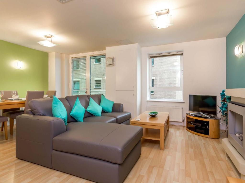 a living room with a couch and a television at Baywatch - Private Balcony Overlooking Poole Quay in Poole