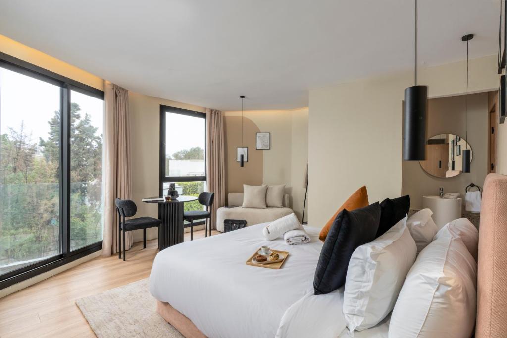 a bedroom with a large white bed and a living room at Corner Residence by GoodMove - Casablanca in Casablanca