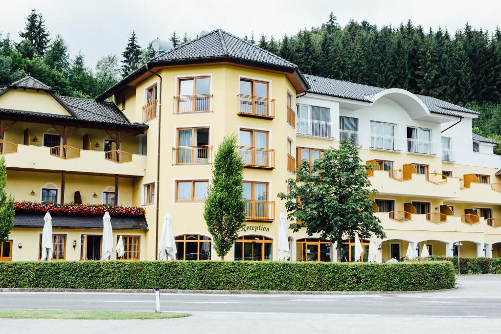 ein großes gelbes Gebäude mit Bäumen im Hintergrund in der Unterkunft Wellnesshotel Aumühle in Grein