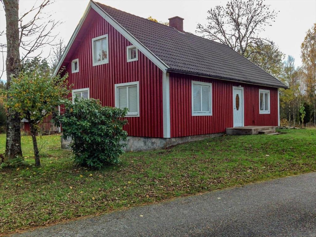a red and white house with a tree in front of it at KRO803-Haeradsbaeck-Ellagoelshult-4 in Häradsbäck