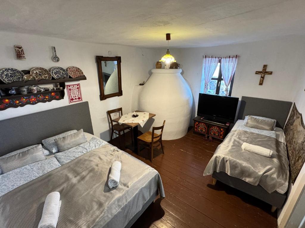 a bedroom with two beds and a cross on the wall at Kotlós Tanya in Zákányszék