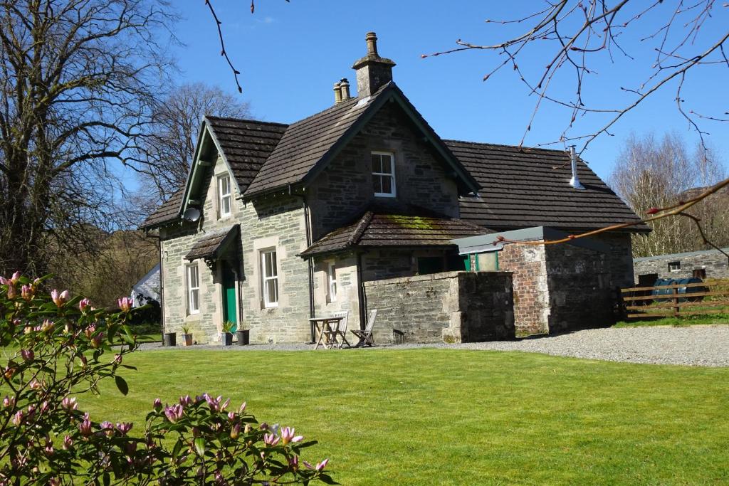 an old stone house with a black roof at The School House in Lochgilphead