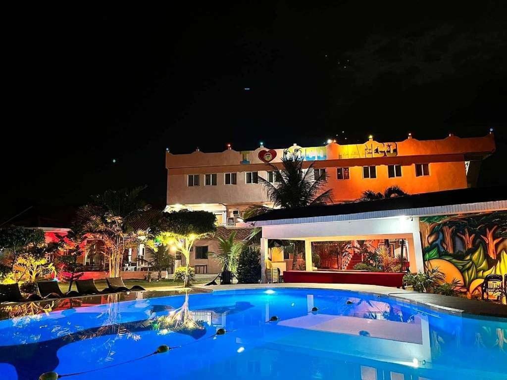 a large blue swimming pool in front of a building at Cocomango's Resort in Taporok