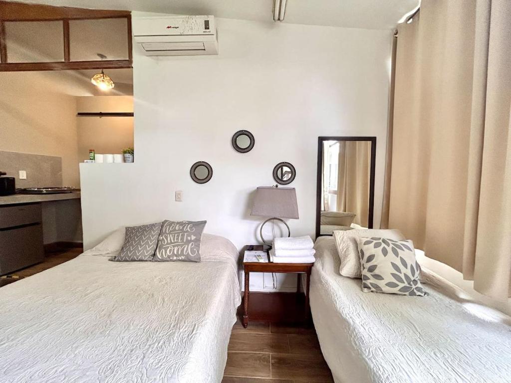 a bedroom with two beds and a table with a lamp at Habitacion olas altas in Mazatlán