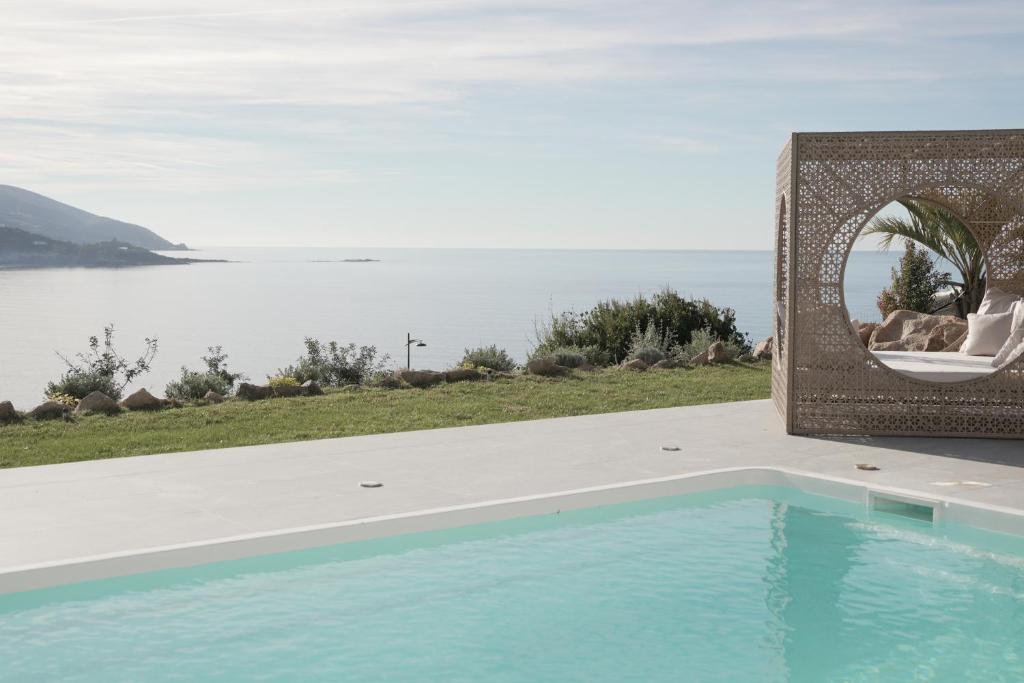a swimming pool with a view of the water at villa la baies des anges in Calcatoggio