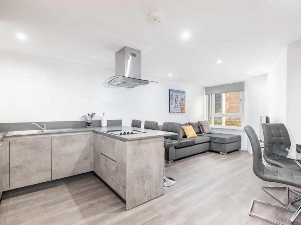 a kitchen and a living room with a couch at Casa Fresa - Castlehill Apartment in Dundee