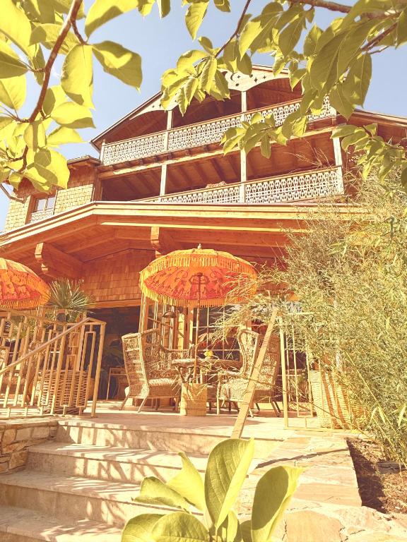 a house with chairs and an umbrella in front of it at SEIN Boutique Suites - ADULTS ONLY in Gosau