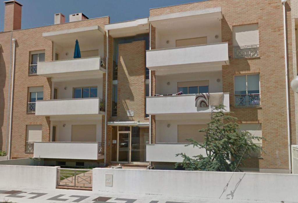 un edificio de apartamentos con balcones blancos en el lateral en Apartamento Areal, en Torreira