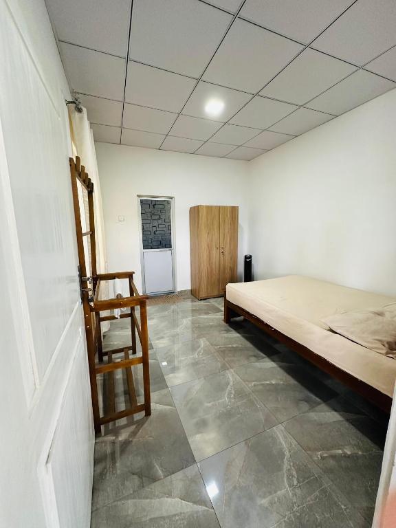 a bedroom with a bed and a chair in it at Aththanayaka walawwa in Polgolla