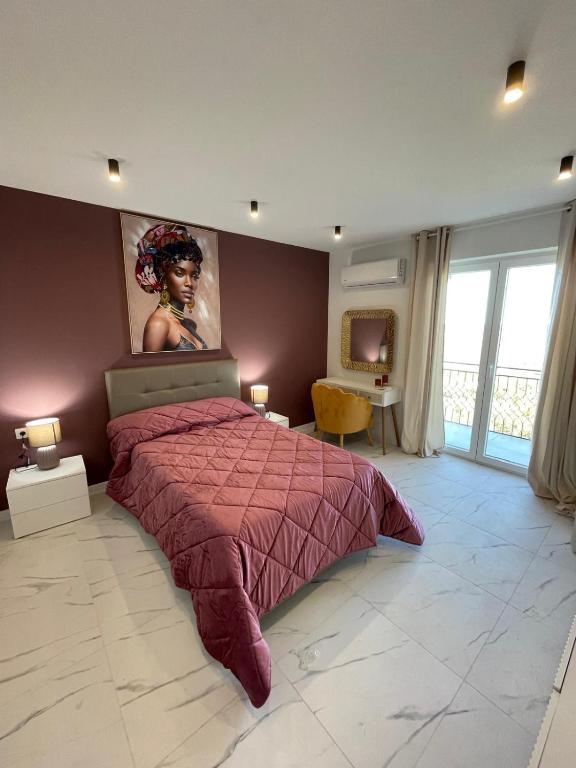 a bedroom with a bed with a painting on the wall at Nela in Carini