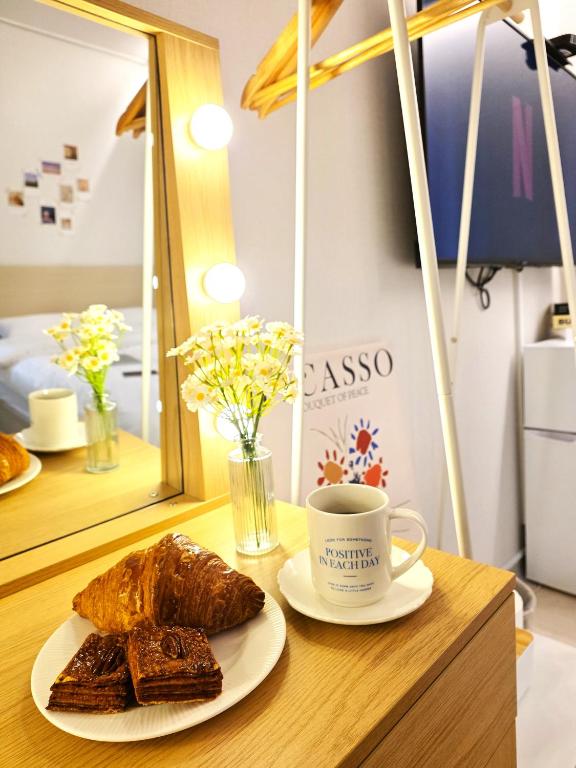 a table with a plate of bread and a cup of coffee at Bom Stay in Seoul