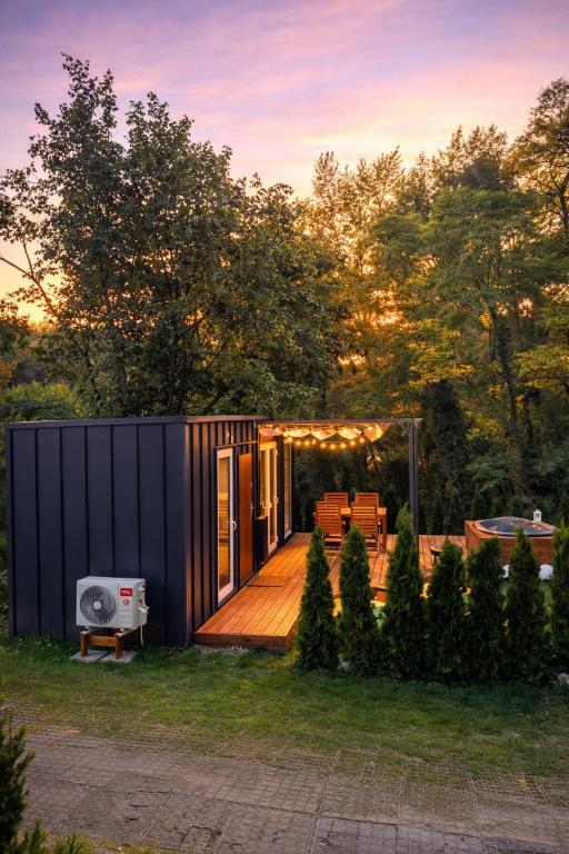 a tiny house in a garden with a deck at Wisla66 Domki nad Wisłą Piotrawin in Piotrawin