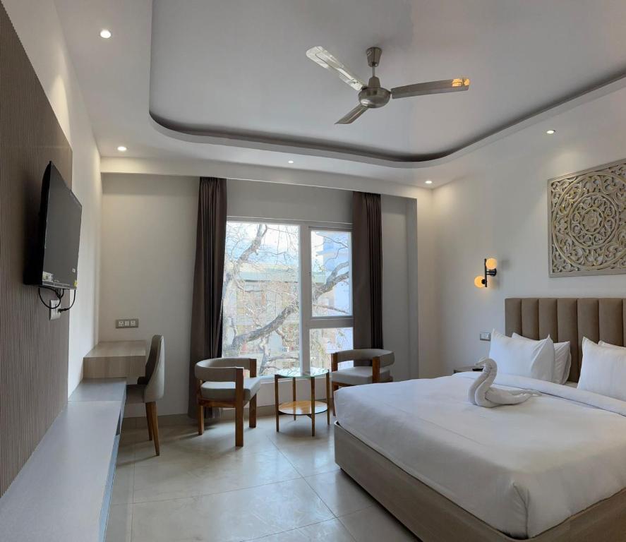 a bedroom with a bed and a desk and a window at Hotel Ivory Hills in Kotdwāra