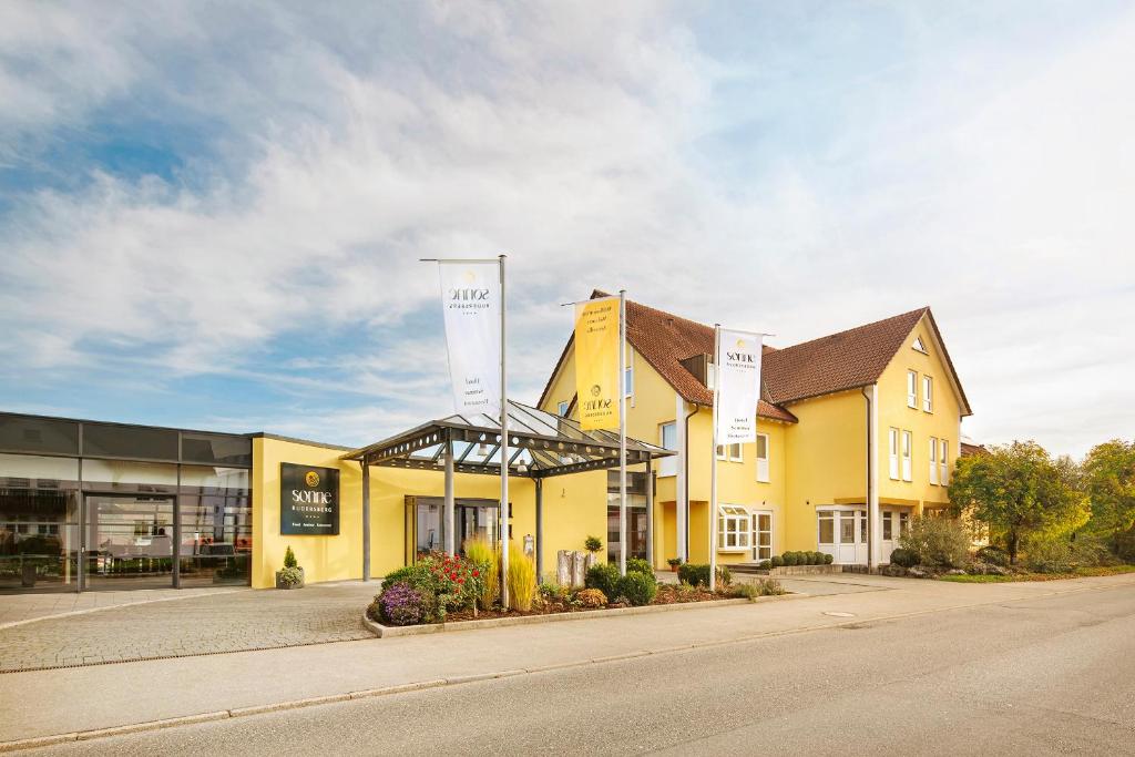 a yellow building on the side of a street at Hotel Sonne Rudersberg in Rudersberg