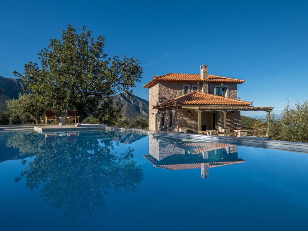 a villa with a swimming pool in front of a house at Dio Escapes Villas in Poulithra