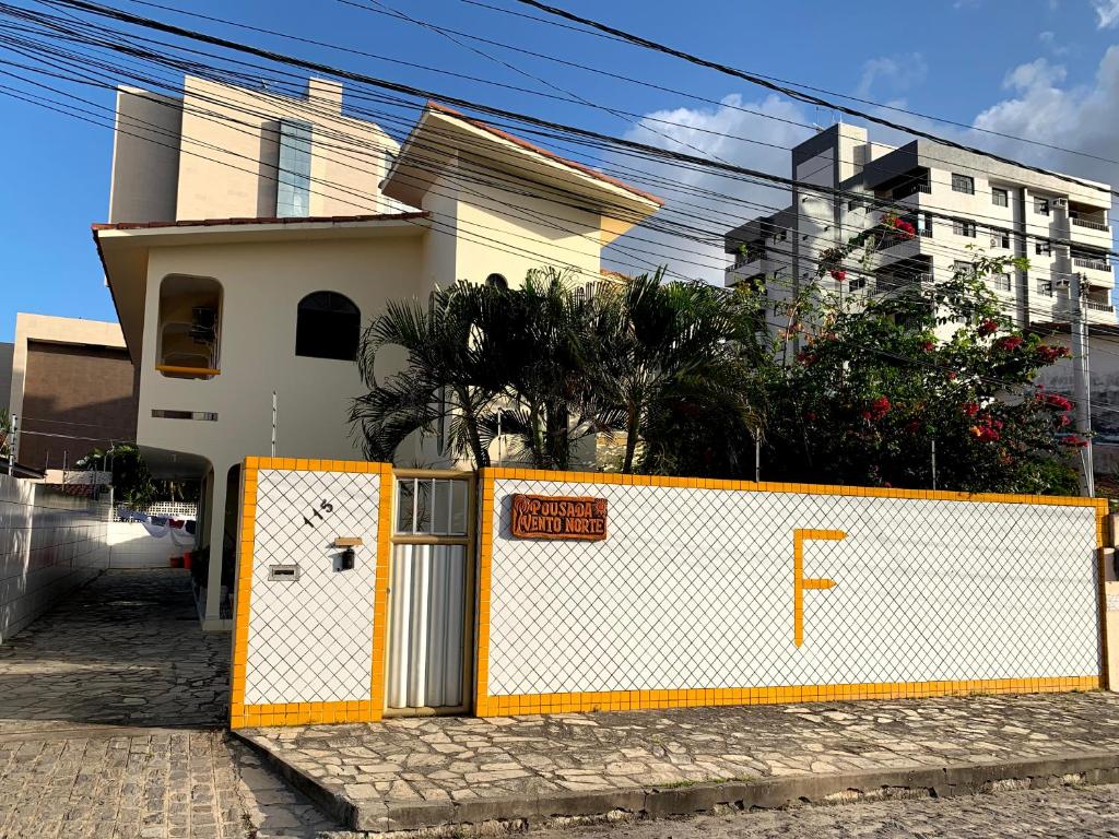 a white and orange fence in front of a house at POUSADA VENTO NORTE CAMA & CAFÉ SUÍTES INDIVIDUAIs in João Pessoa