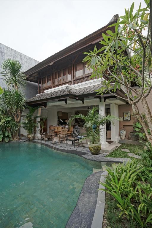 a house with a swimming pool in front of it at Juan Villa Legian in Seminyak
