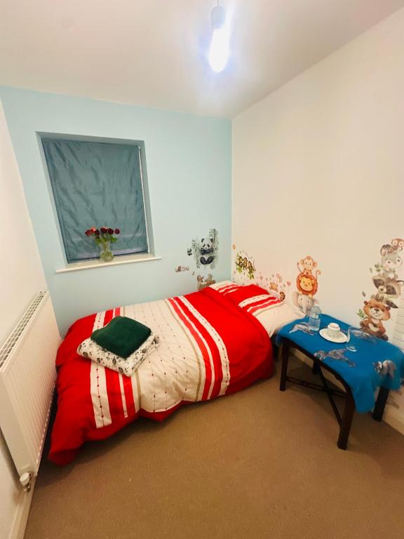a bedroom with a red bed and a table at Stay with LL in Doncaster