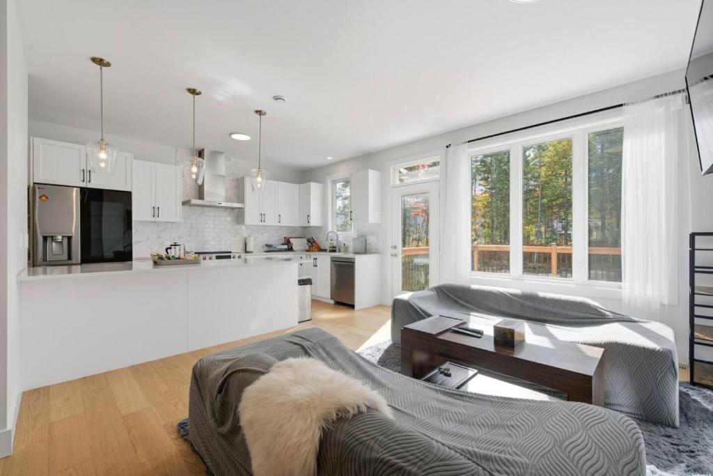 a white living room with a couch and a kitchen at Quiet and Convenient Retreat in Hammonds Plains