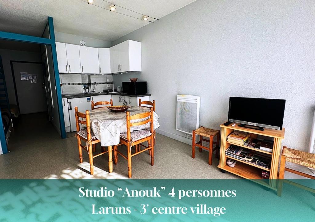 a living room with a table and a kitchen at Studio Anouk 4 personnes à Laruns in Laruns