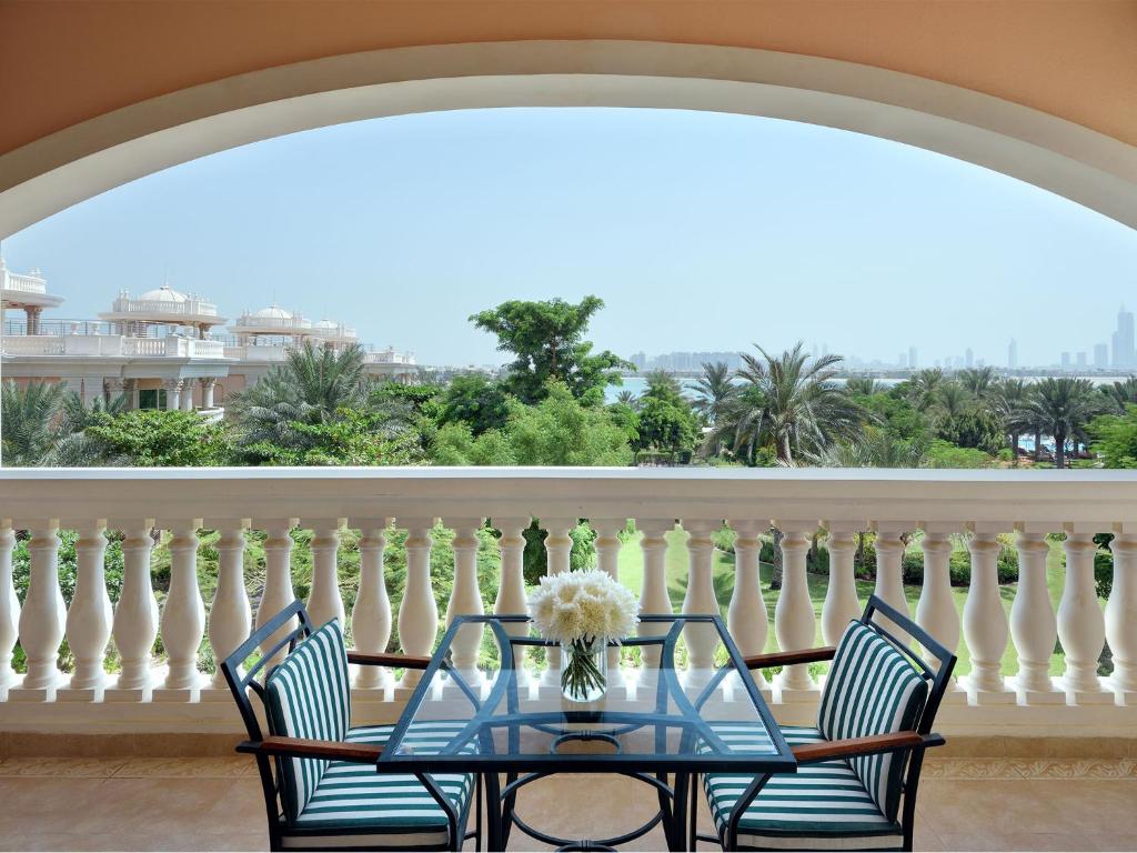 a table and chairs on a balcony with a view at Kempinski Hotel Palm Jumeirah in Dubai
