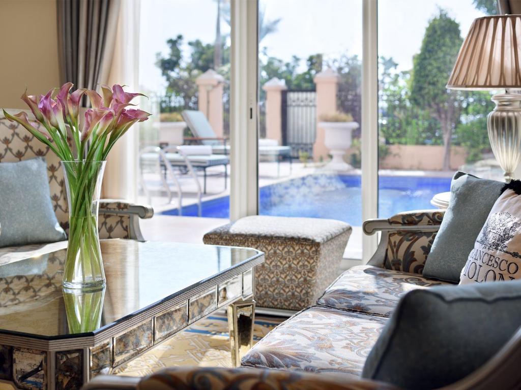 a living room with a vase of flowers on a table at Kempinski Hotel Palm Jumeirah in Dubai