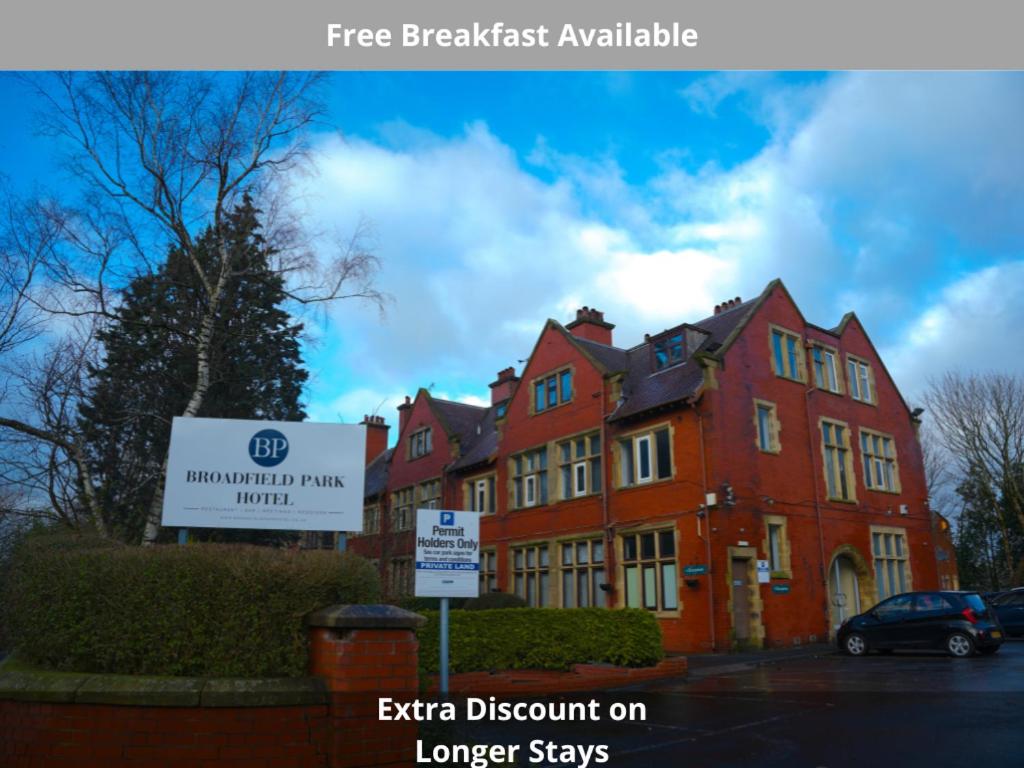 a large red building with a sign in front of it at Broadfield Park Hotel by Belvilla in Rochdale