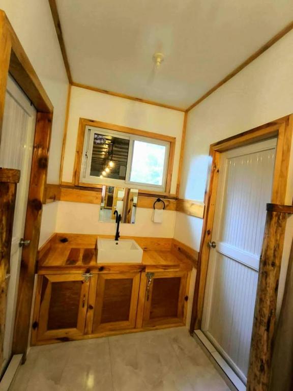 a small bathroom with a sink and a mirror at Lolo Dads Cabin in Sagada