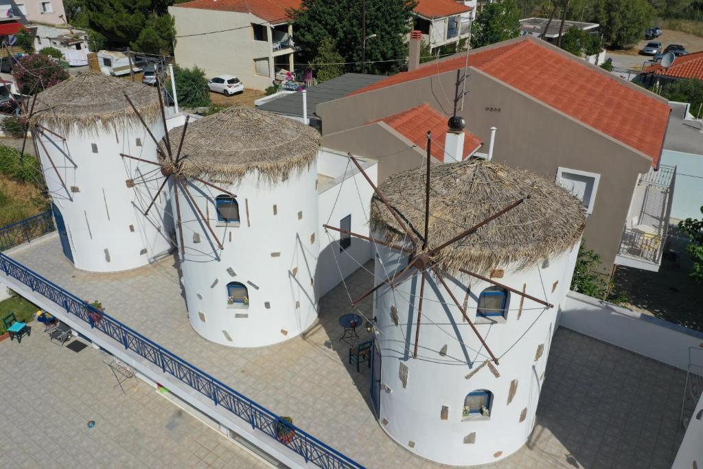 two windmills with straw roofs on top of a building at Ξενώνες Ανεμόμυλοι - Windmills Hotel in Panayía