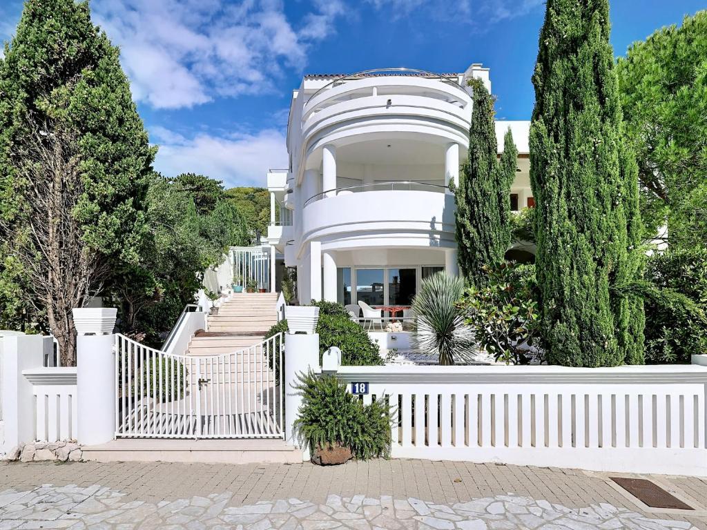 a white house with a white fence and trees at Villa Perla Baska in Baška