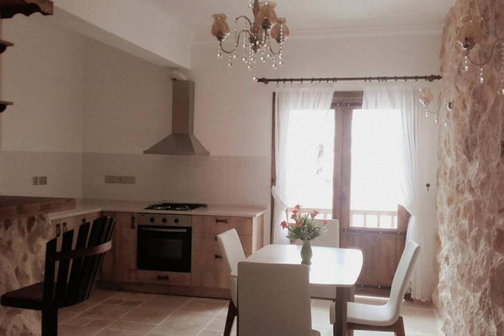 een keuken met een tafel en stoelen en een raam bij Doga Apartment in Famagusta