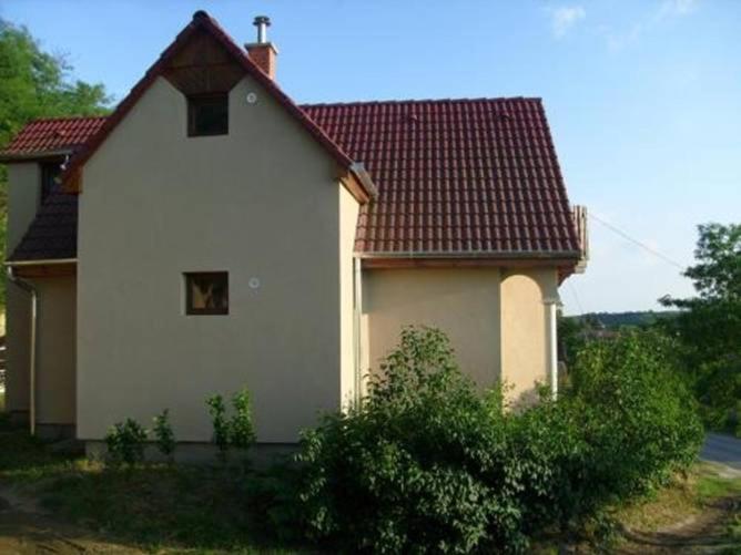 a small white house with a red roof at Sas-Fészek Vendégház in Demjén