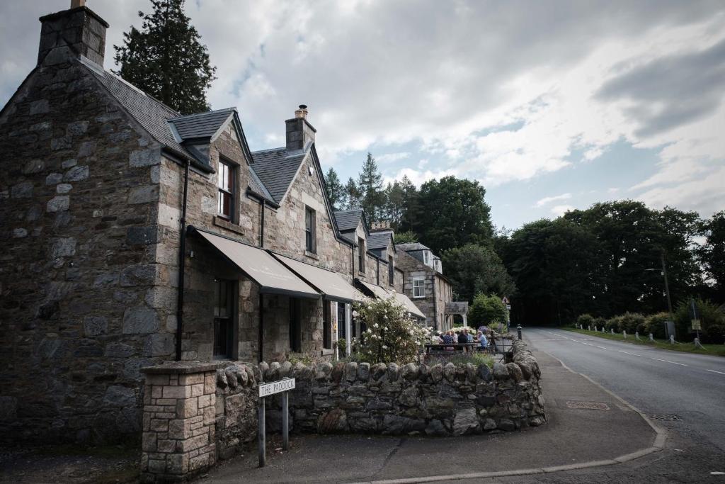an old stone building on the side of a road at The Grandtully Hotel in Grandtully
