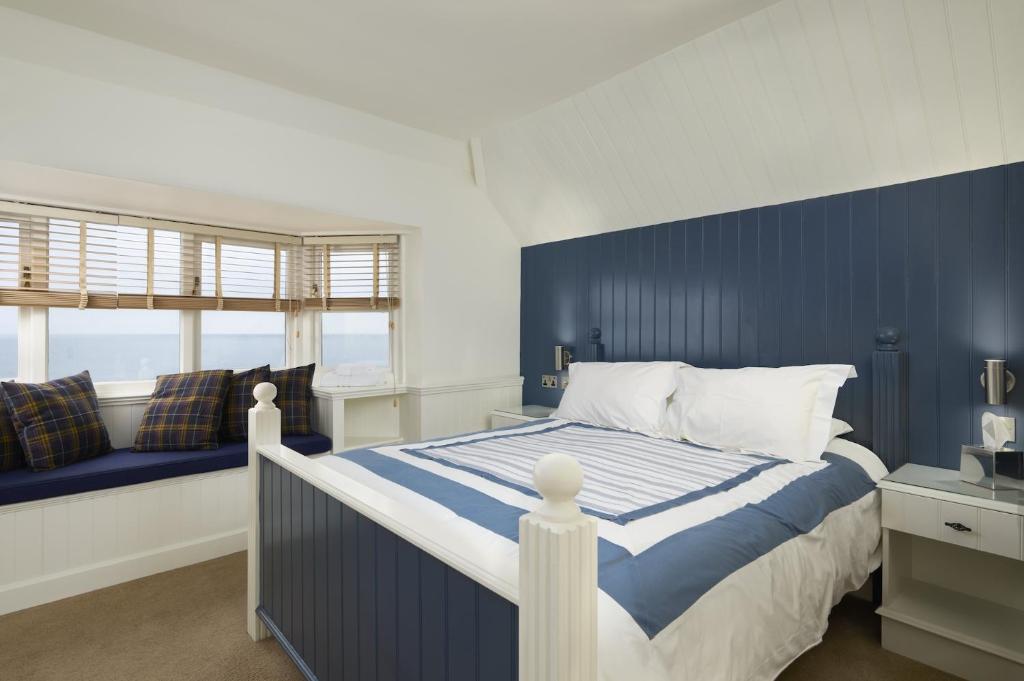 a blue and white bedroom with a bed and a window at The Cricket Inn in Kingsbridge