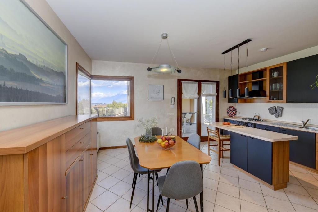 a kitchen and dining room with a table and chairs at Villa Bella by Garda FeWo in Manerba del Garda