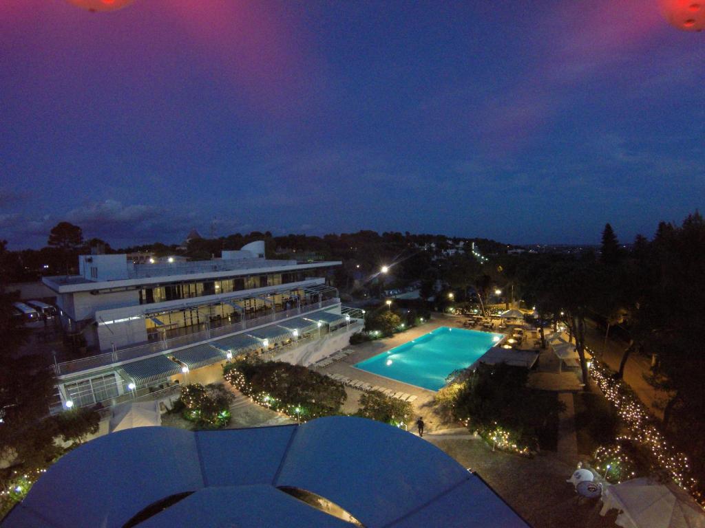 vista su un edificio con piscina di notte di Hotel Sierra Silvana a Selva di Fasano