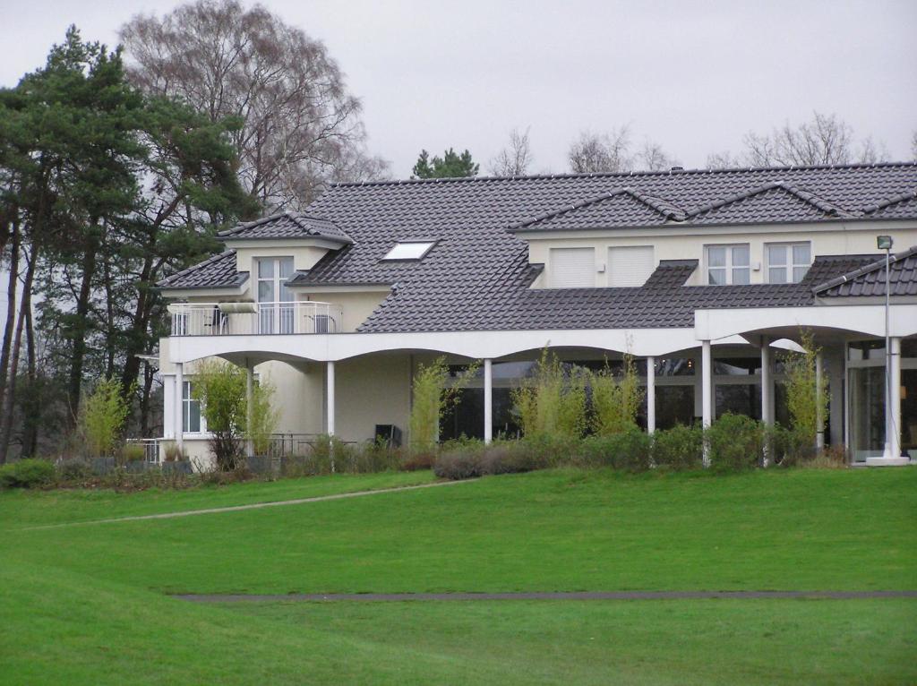 ein Haus mit grünem Rasen davor in der Unterkunft Golfhotel Rheine Mesum in Rheine