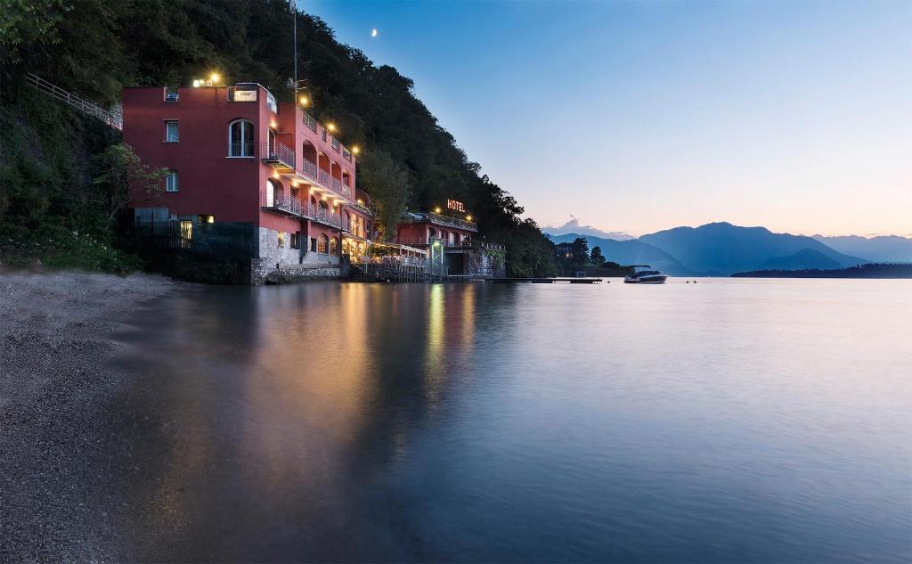 a building on the shore of a lake at night at Il Porticciolo in Laveno-Mombello