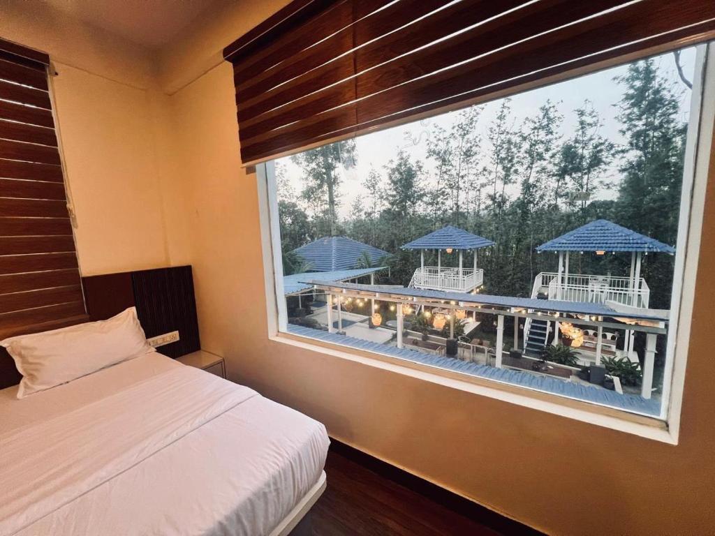 a bedroom with a window with a view of a patio at Aetheria Estate Retreat in Chikmagalūr