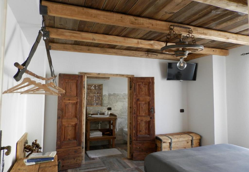 a bedroom with a bed and a wooden ceiling at B&B Le Ciaf in Temù