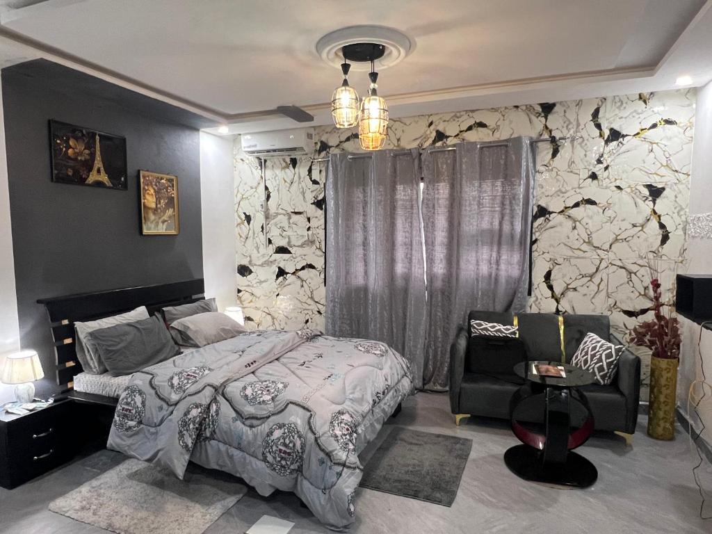 una camera da letto con un letto king size e una sedia di Beni'o Suite a Adiapo-Doumé