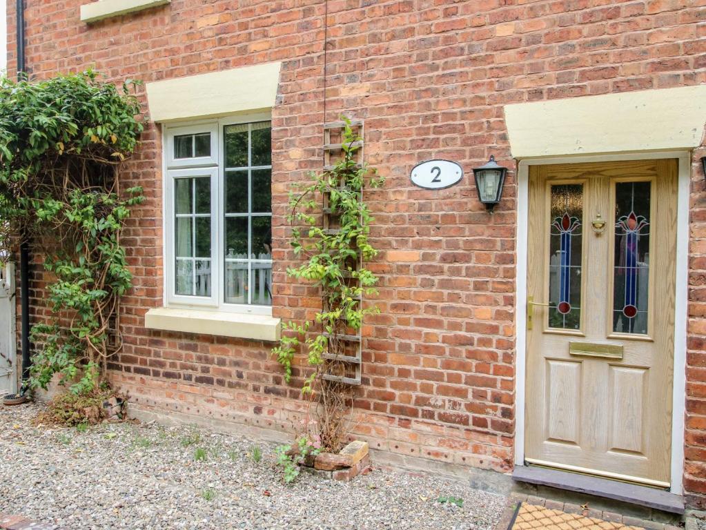a brick building with two windows and a door at 2 Aqueduct Cottages in Wrexham