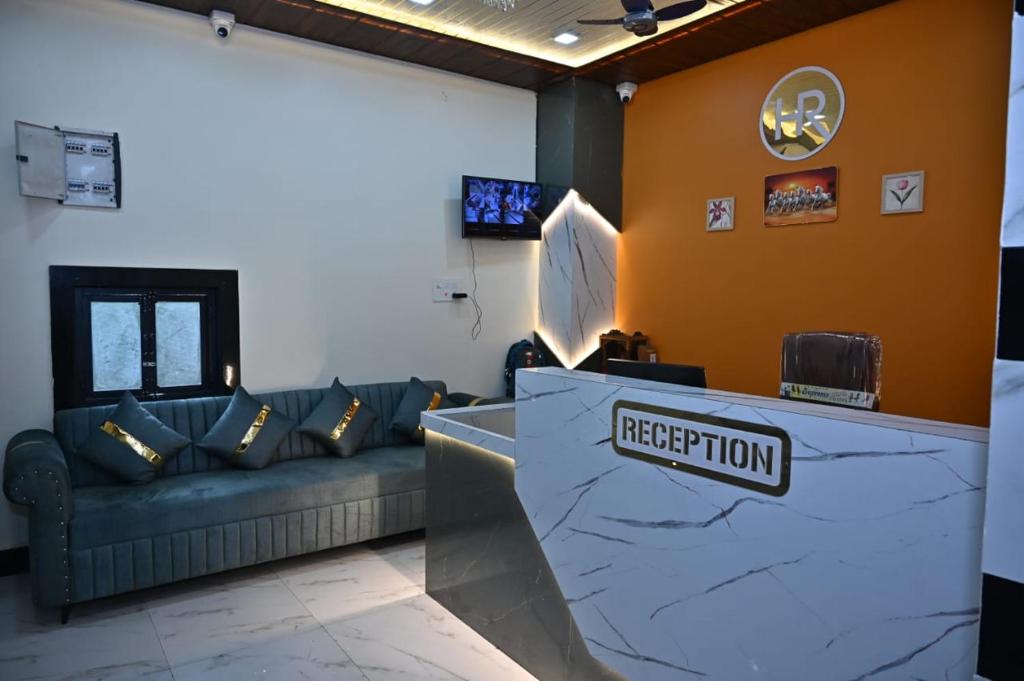 a lobby with a couch and a reception counter at Hotel Radhe in Bhind