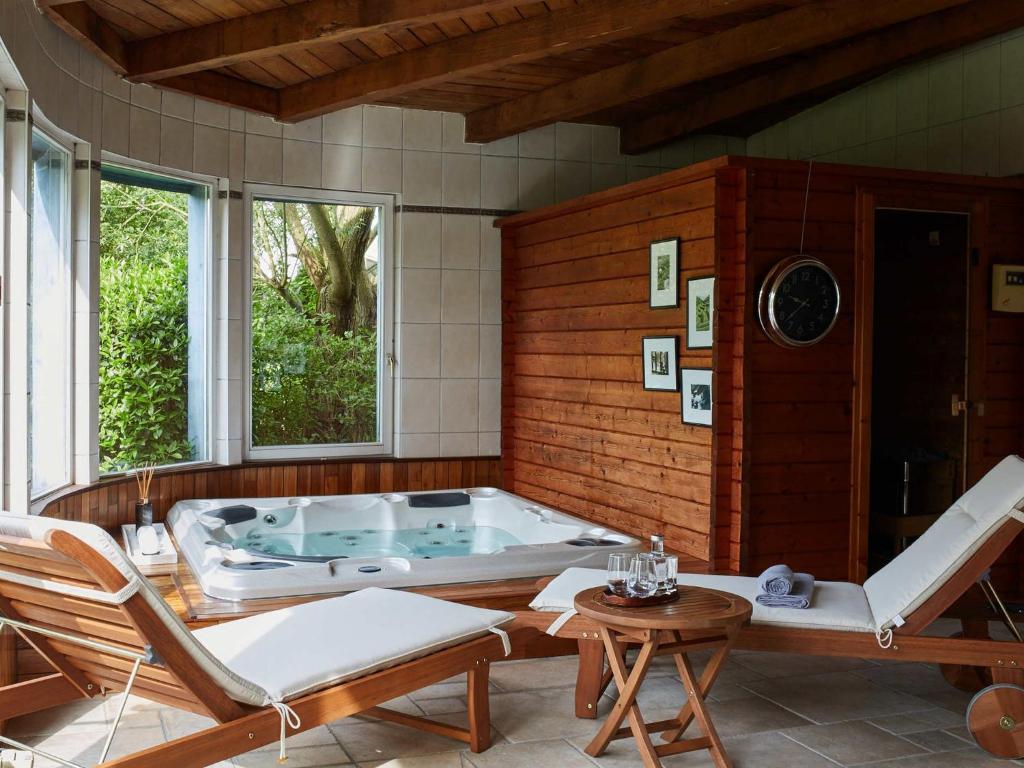 a hot tub in a room with chairs and a table at Les Prés D'ondine in Sélestat