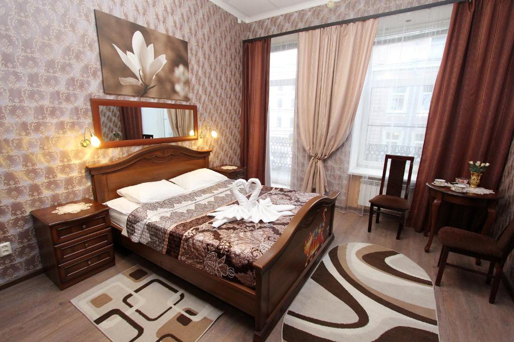 sypialnia z łóżkiem i lustrem na ścianie w obiekcie Guest House Geralda on Nevskiy w Petersburgu