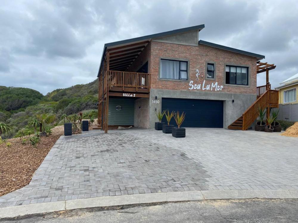 a house with a large driveway in front of it at Sea La Mer Villa in Wilderness
