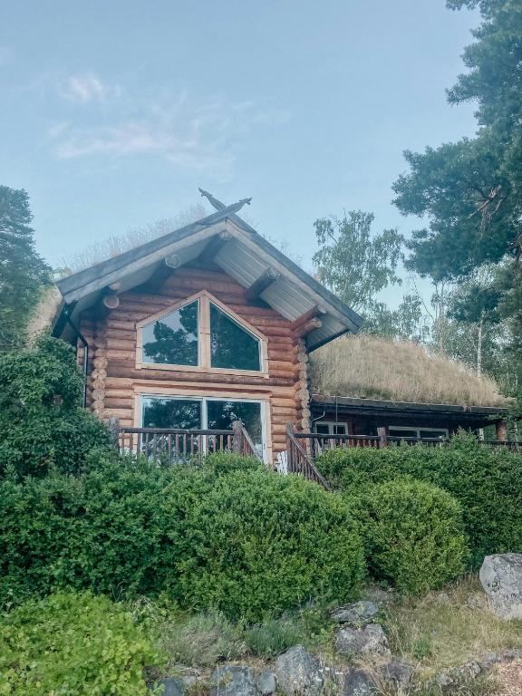a log cabin with a thatched roof at Modern Log Cabin On Adelsö in Adelsö