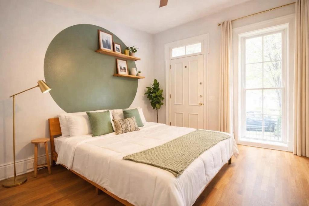 a bedroom with a large bed with a green wall at Remodeled Modern Home - private backyard & games! in Louisville