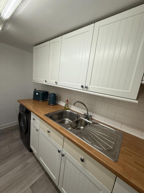 a kitchen with a sink and white cabinets at Glen Allan Hotel in Blackpool